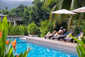 a woman sitting in a chair next to a swimming pool at Senda Beach House Tayrona in Buritaca +22 photos