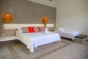 a bedroom with two beds with red pillows on them at Senda Beach House Tayrona in Buritaca