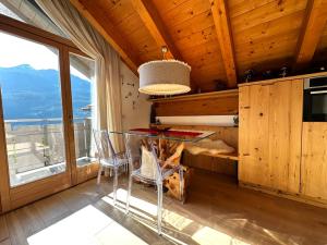 a dining room with a table and a large window at Appartamento Picchio in Bormio