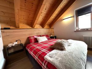 a bedroom with a bed in a room with wooden ceilings at Appartamento Picchio in Bormio