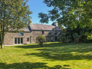 a large stone house with a grass yard at Morfa Ganol in Llangranog