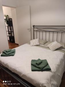 a bed with two green towels on top of it at amaRE in Reggio Emilia