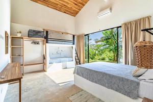 a bedroom with a bed and a large window at Private rainforest villa up to 8 guests w jacuzzi near Rio Celeste in Upala