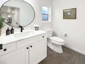 um banheiro branco com um vaso sanitário e um espelho em The Maverick Haus townhouse em Grand Junction