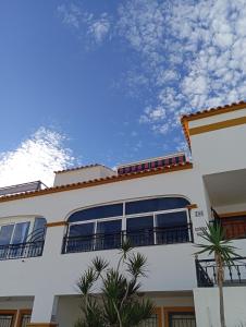 ein weißes Gebäude mit Palmen davor in der Unterkunft Casita Stam Orihuela in Orihuela