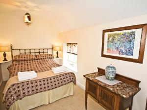 une petite chambre avec un lit et une table dans l'établissement Brook House Farm Cottage, à Church Minshull
