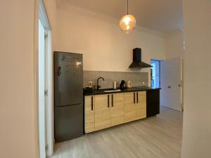 a kitchen with a refrigerator and a sink at The Pearl Suite - your stylish cozy and modern flat,in the heart of South Tenerife,just 3 minutes from beach and natural pools in Alcalá