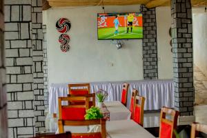 ein Raum mit einem Tisch und einem Fernseher an der Wand in der Unterkunft Kigufi Hill Hotel & Agape Resort in Gisenyi