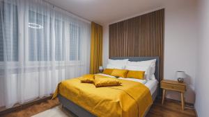 a bedroom with a large bed with yellow sheets at Apartmán Astana in Levoča