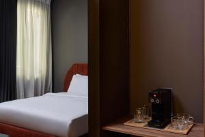 a bedroom with a bed and a speaker on a table at Athens Icon Collection in Athens