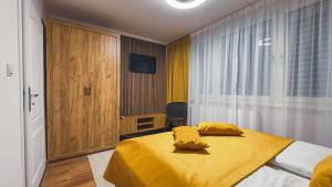 a bedroom with a bed with yellow sheets and a window at Apartmán Astana in Levoča