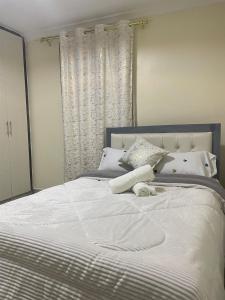 a large white bed with white sheets and pillows at Calm getaway in Rongai in Ongata Rongai 