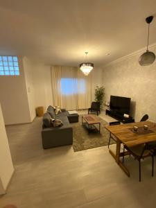 a living room with a couch and a table at The Pearl Suite - your stylish cozy and modern flat,in the heart of South Tenerife,just 3 minutes from beach and natural pools in Alcalá