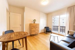 een woonkamer met een tafel en een bank bij Charming Apartment in St Moritz in St. Moritz +17 foto's