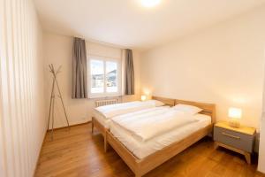 een slaapkamer met een groot bed en een raam bij Charming Apartment in St Moritz in St. Moritz