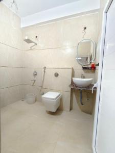 ein Badezimmer mit Toilette, Waschbecken und Spiegel in der Unterkunft Private room & attached washroom 102 , Zero mile in Patna + 9 Fotos
