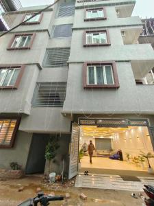 a man walking in front of a building at Private room & attached washroom 102 , Zero mile in Patna