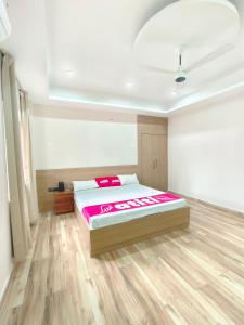 ein Schlafzimmer mit einem Bett und einem Holzboden in der Unterkunft Private room & attached washroom 102 , Zero mile in Patna