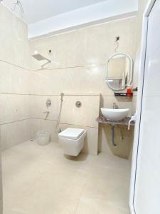 ein Badezimmer mit Toilette, Waschbecken und Spiegel in der Unterkunft Private room & attached washroom 102 , Zero mile in Patna