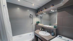 a bathroom with a sink and a tub and a mirror at Apartmán Astana in Levoča +4 photos