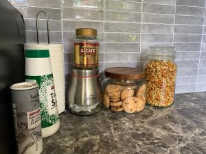 a kitchen counter with jars of food on it at Stylish Chic King Bedroom in Mount Colah