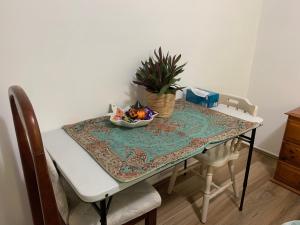 a table with a bowl of fruit and a plant on it at Stylish Chic King Bedroom in Mount Colah +10 photos
