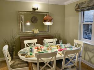 une salle à manger avec une table et des chaises blanches dans l'établissement Tower Cottage - Mvw, à Belsay