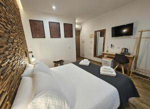 um quarto com uma grande cama branca e um espelho em ARYA Cagliari em Cagliari mais 31 fotografias