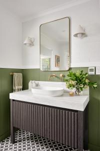 a bathroom with a sink and a mirror at Oak Ridge Cottage in Maleny