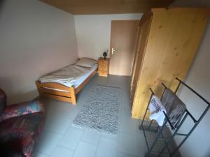 una pequeña habitación con una cama y una silla en Haus Erlenweg, en Neuenkirchen-Vörden