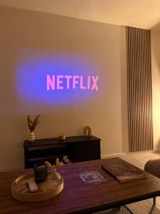 een neonbord met de tekst Netflix op een muur bij Le Monde des Dunes - T3 - Parking privé in Angers +9 foto's