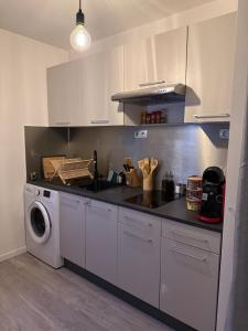 een keuken met een spoelbak en een wasmachine bij Le Monde des Dunes - T3 - Parking privé in Angers