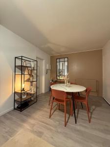 een eetkamer met een tafel en stoelen bij Le Monde des Dunes - T3 - Parking privé in Angers