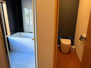 a bathroom with a tub and a toilet in a room at 苗場サンバレーホテル in Minami Uonuma