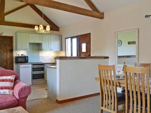 ウェストルトンにあるThe Cart Shed - E1768のテーブルと椅子のあるキッチンとダイニングルーム