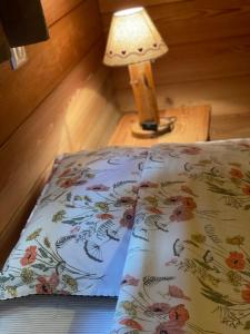 een bed in een kamer met een lamp op een tafel bij Au Solé in Basse-sur-le-Rupt