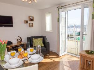 a living room with a table and a balcony at 1 Harbour View in Newquay