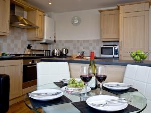 a kitchen with a table with two glasses of wine at 1 Harbour View in Newquay