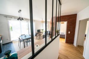 a dining room and living room with glass windows at T3 BROOKLYN - Luminous - Central - Wifi - Parking in Nanterre