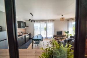 a kitchen and living room with a table and chairs at T3 BROOKLYN - Luminous - Central - Wifi - Parking in Nanterre
