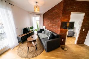 a living room with a couch and a brick wall at T3 BROOKLYN - Luminous - Central - Wifi - Parking in Nanterre +34 photos