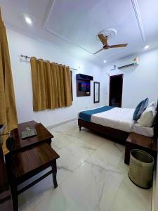 Un dormitorio con una cama y una mesa en una habitación. en Hotel the Chandigarh, en Chandīgarh