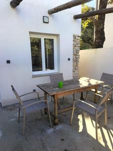 una mesa de madera y sillas frente a una casa en Charmante maisonnette 1 chambre proche de Nîmes, en Caveirac