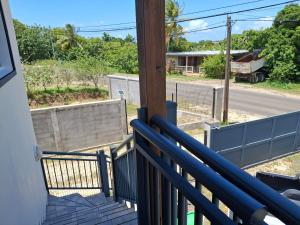 a balcony with a blue railing and a street at Haut de maison T4 à Petit Canal in Petit-Canal