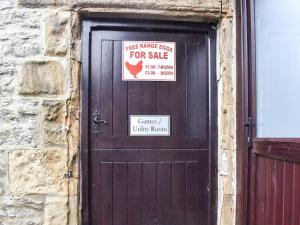 a wooden door with two signs on it at Haddon Cottage - Uk40270 in Bakewell