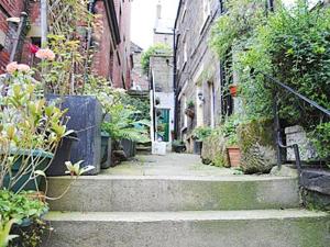 an alley with stairs leading down to a building at Cobweb Cottage in Whitby