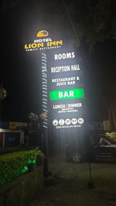 a sign for a restaurant with a neon sign at Hotel Lion Inn in Bandarawela