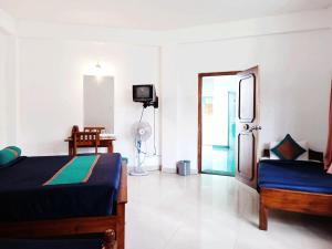 a bedroom with two beds and a tv in it at Hotel Lion Inn in Bandarawela