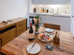 a table with a bottle of wine and a bowl of fruit at The Sail Loft - Royal William Yard in Millbrook