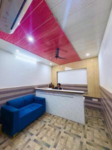 Un hombre sentado en un bar con un sofá azul en Hotel the Chandigarh, en Chandīgarh